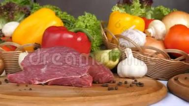 在生菜叶、香料、咖喱、辣椒等蔬菜的背景下，不同种类的肉放在木板上